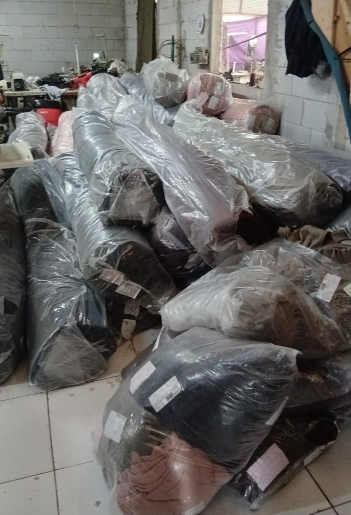 Gulungan dan bundel kain siap produksi di workshop Vertex